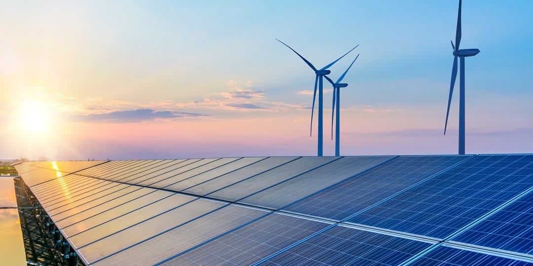 Solar panels with windmills in the background